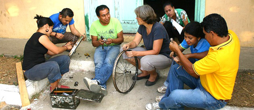 MIT D-Lab Founding Director Amy Smith (center) with inventor and Bici-Tec Founder Carlos Marroquin (third from left), working with members of a community in El Salvador.