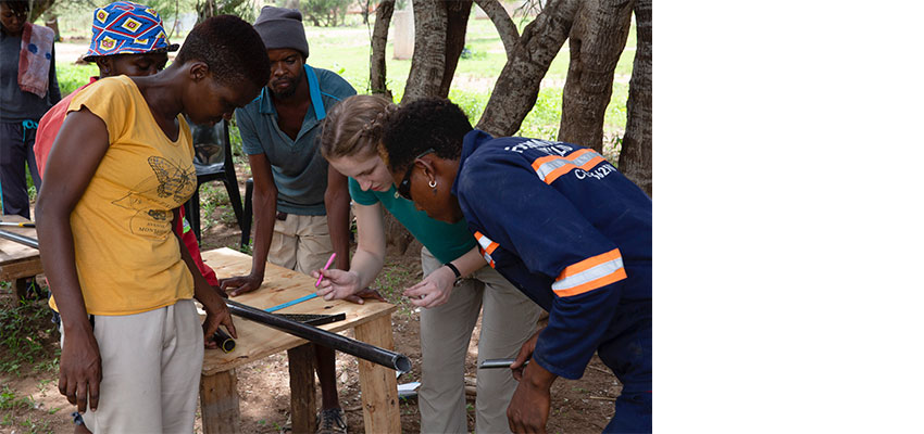 Amelia Seabold 2022 (2nd from right) takes careful measurements with   Maikano Poniso (yellow shirt) and Nyambe Namate (overalls).