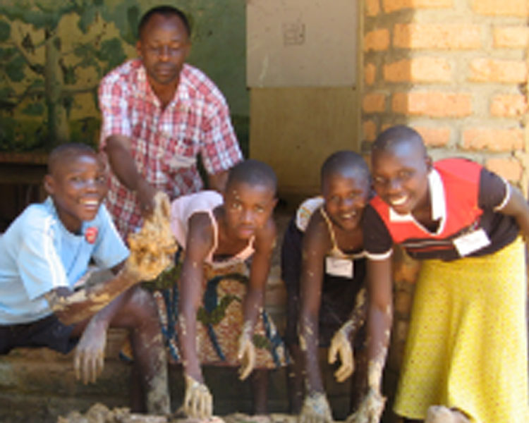 Youth building a stove in Kasiisi, Uganda.