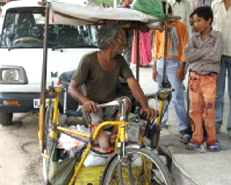 A polio survivor in Jaipur, India uses a handcycle for mobility and income generation.