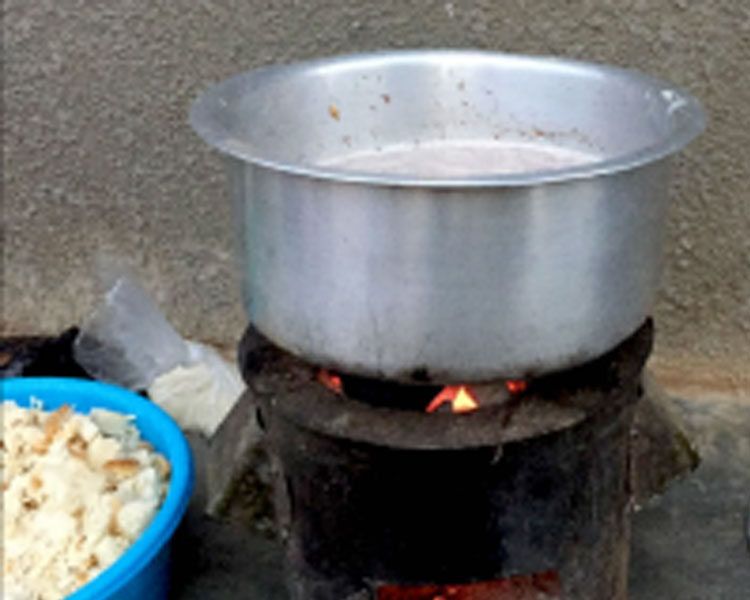 Cookstove in use with bread cubes at the side.
