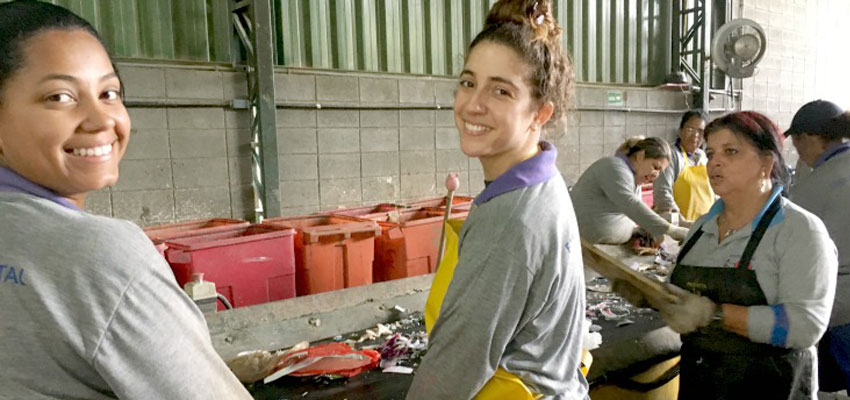 Jessica (left) and Peña (right) showing Talia how to sort recyclable materials at the Jacareí Recicla cooperative in Jacareí, São Paulo.