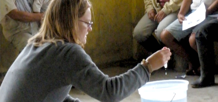 Kendra Johnson demonstrating how to chlorinate water in La Encañada, Ecuador, 2009. 