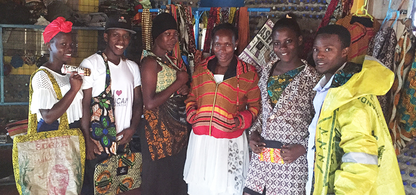 The Kimuli Fashionability team showcases some of its products that it has recently created. The founder, Juliet Namujju (far left), became inspired to blend African fabrics with recyclable materials based on her childhood experience of watching her grandmother practice her trade as a tailor. 