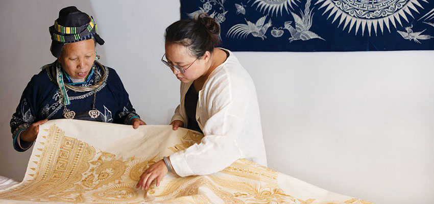 Xiao Liu, right, a community organizer with Roots Studio, looks over a print with an artist from Guizhou, China. Photo: 心奕 