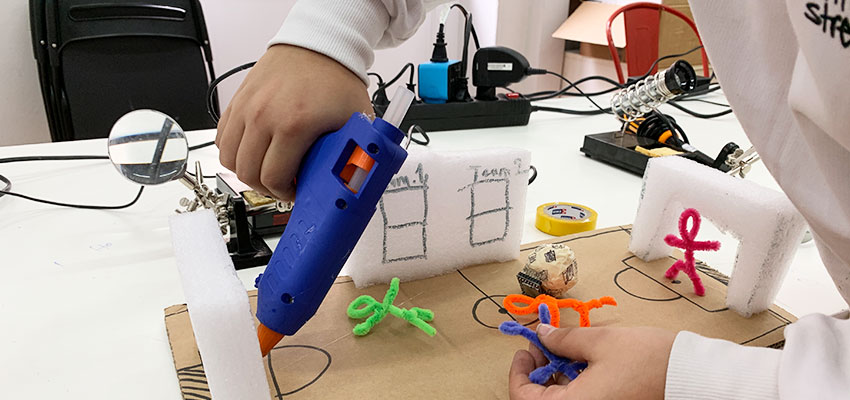 A student builds a sketch model of his idea to design a soccer ball with a chip inside it that connects to the score board, automatically adding a point when a goal is scored.