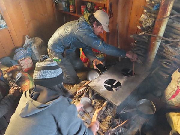 Dan Sweeney and Connie Ly working to remove ash buildup from a local resident’s stove in Kyanjin Gompa, Nepal. 
