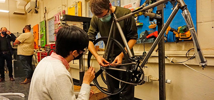 IAP Build Your Own Bike participants graduate student John Zhang (left) and senior Sam Ingersoll (right) tinkering with a chain. Photo: Courtesy MIT D-Lab
