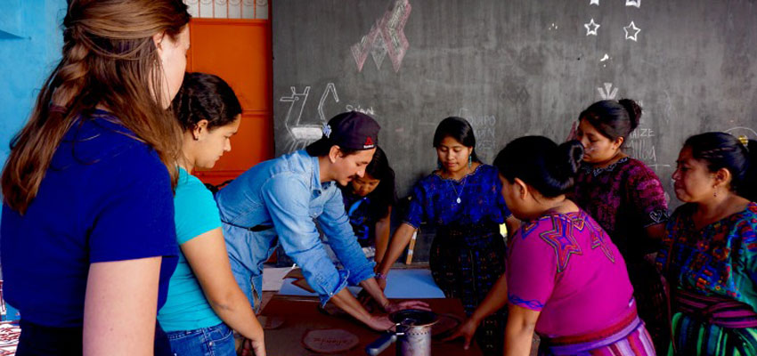 Team member Natalie & Link4 Co-Founder Omar Crespo work with community members on stage 3 of the workshop manipulating cardboard cutouts to determine ideal size of cookstove.
