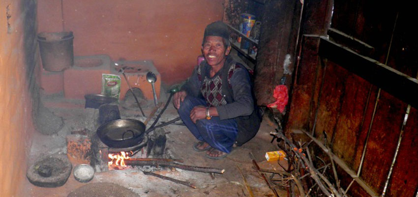 A resident from Salambu cooking food using forest wood.