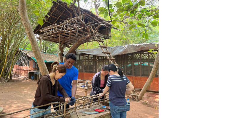 Four people assembling a bamboo frame.