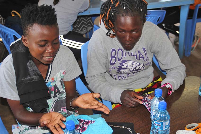 Participants testing out commercial reusable pads. Oyugis, Kenya, Jan. 2020.