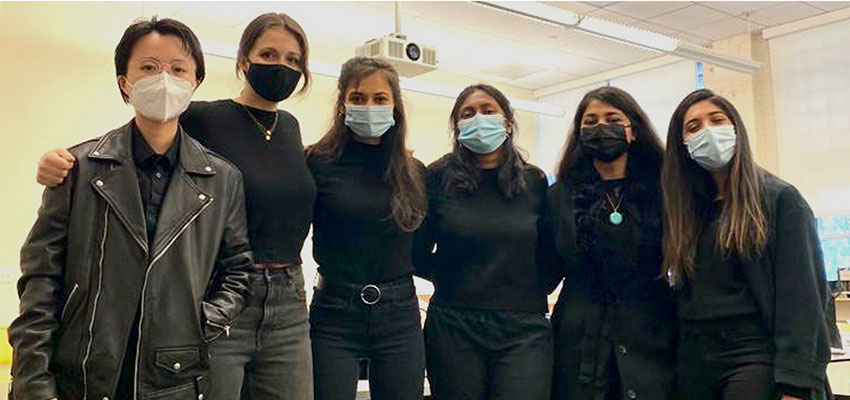 Women standing wearing surgical masks.