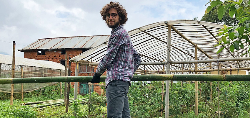 Matthew Baldwin carrying bamboo to the site of the greenhouse construction.