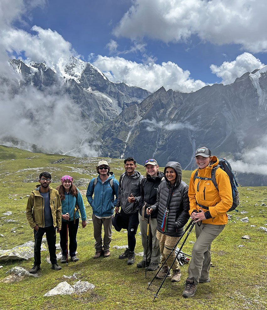 Eight people standing in scenic high-elevation mountain area in Nepal.
