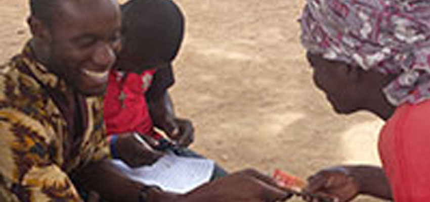 Kwami Williams pays a Ghanain farmer for moringa seeds