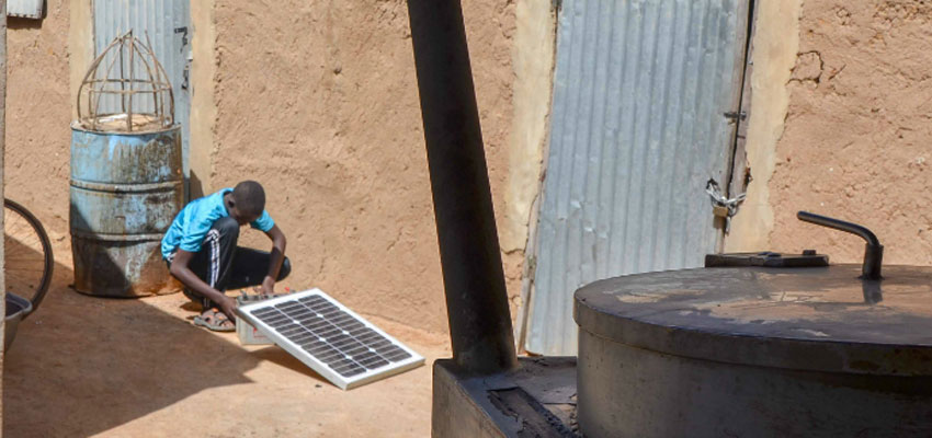 Young man with solar panel in Dioro, Mali.