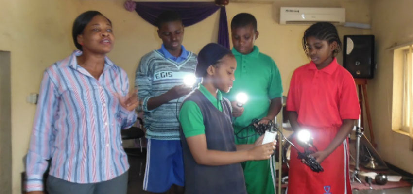 Angela Amaka Onah (left) giving a solar lantern demonstartion at a local school (Nigeria).
