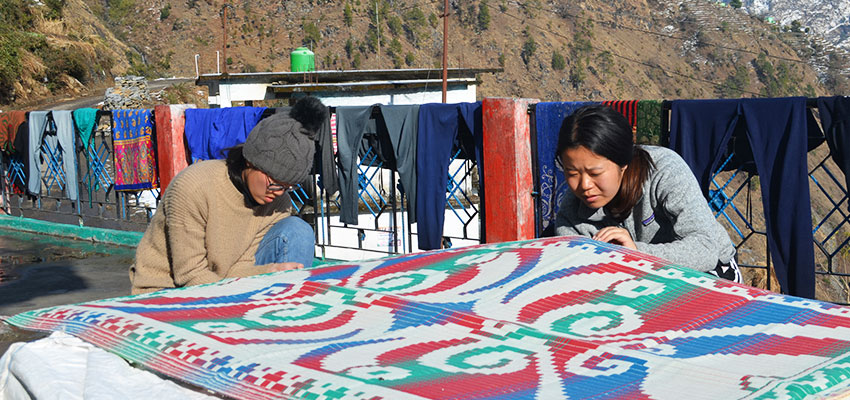 Jackie Lin '19 and Ting Li '20 sewing chatai mats, with foam in between. Nepal, January 2019.
