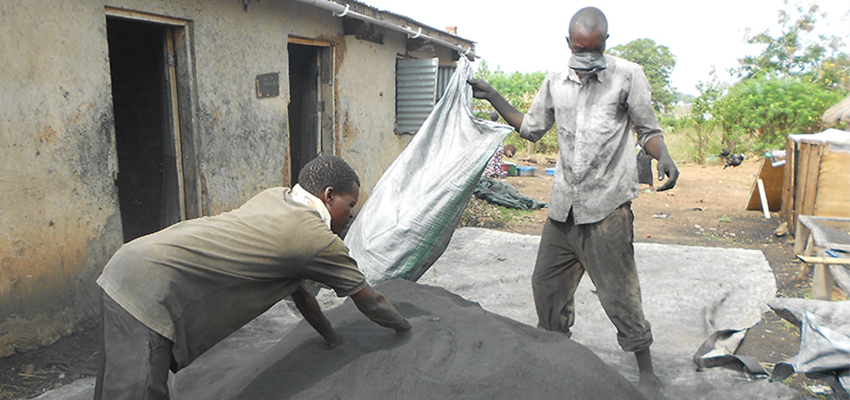 Mixing char and charcoal dust in Soroti, Uganda at Appropriate Energy Saving Technologies (AEST).