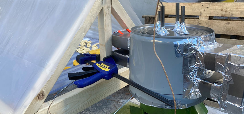 Drying jackfruit, bananas, and mangoes in our solar dryer using the heat exchanger with a double-pass on the Makaa cookstove. Photo: MIT D-Lab