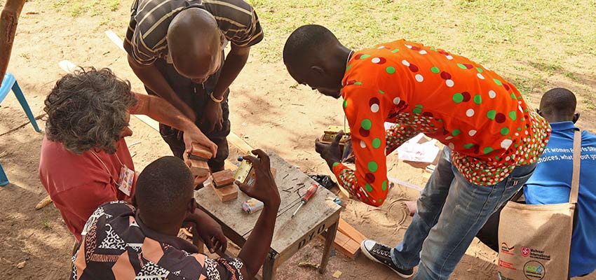 Participants in MIT D-Lab's Co-Creation Summit in Arua, Uganda learning to use tools by building different technologies including a maize-sheller jig. March 2022. Photo: MIT D-Lab
