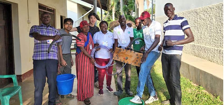 The team poses with the water pump. Left to right: Cosmas (Kulika Uganda), Tarek (D-Lab), Ruta, Alex (D-Lab), Carol (Kulika Uganda), Isaac (Kulika Uganda), Sunday, Amos (Andre Foods International), Philip (Kulika Uganda). Photo: Courtesy Tarek Meah.