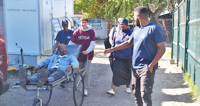 A Langa community member tests the stretcher prototype, pushed by a D-Lab student and accompanied by members of the Langa Bicycle Hub and Kete Impilo. Photo: Courtesy MIT D-Lab