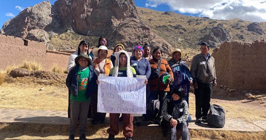 Members of Q’ochas Resilientes holding a poster alongside several attendees of our community co-design workshops in Pucará (Banner translation: Welcome to the Q’ochas Resilientes workshops). Photo: Courtesy MIT D-Lab