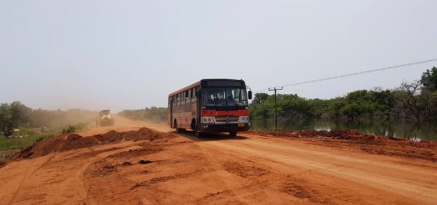 Bus traveling on a dry dusty road.
