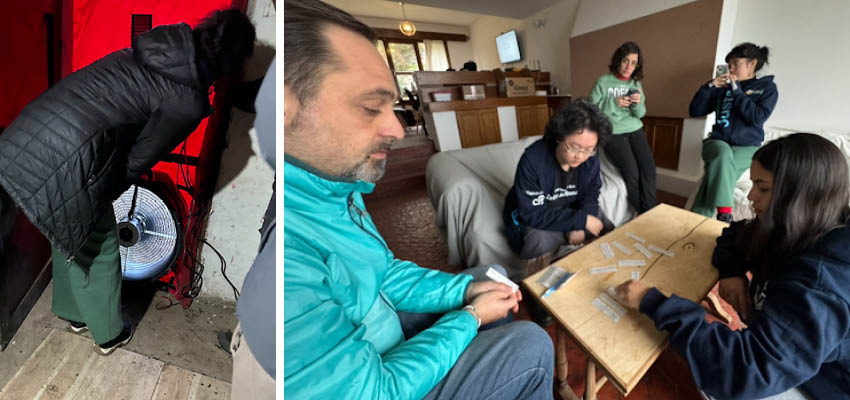 Six people sitting and standing around a table.