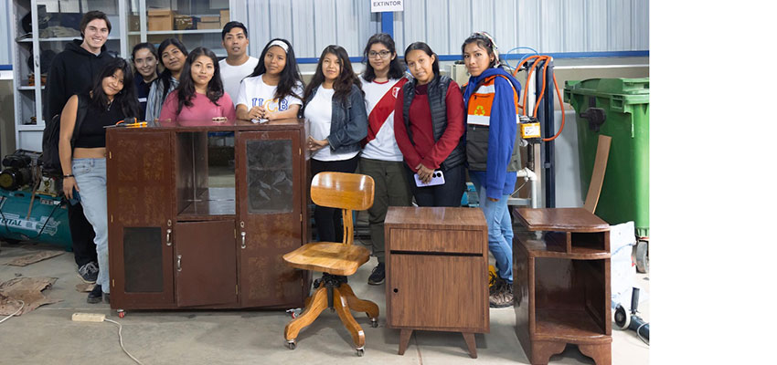 Several people standing with used furniture.