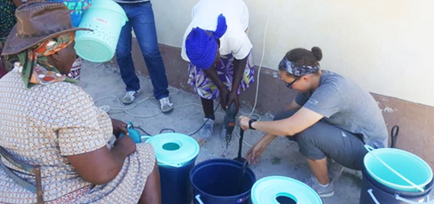 D-Lab student Sloan helps teach local women how to use power drills to create holes in a plunger
