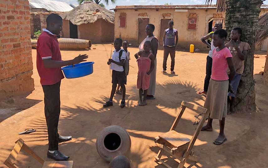 Francis Eteku demonstrates how to assemble a clay pot cooler to Grace Avila in Soroti, Uganda.