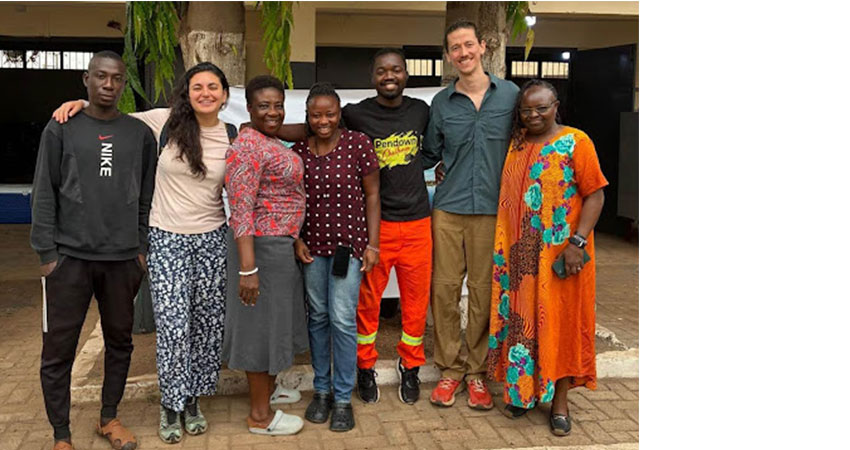 A group of seven adults standing togehter to have their picture taken.