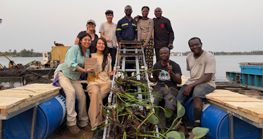 A small group of people on a boat surrounding a ladder covered in wet weeds.