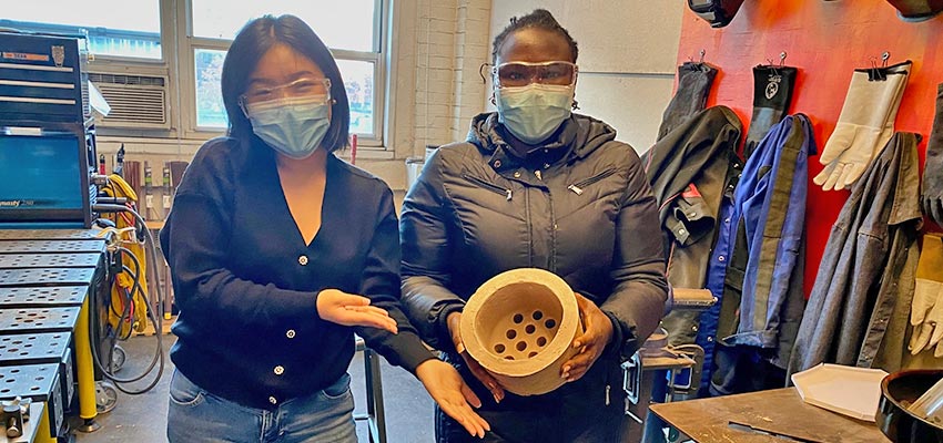 D-Lab student and Happy Amos in welding room with ceramic liner for cookstove