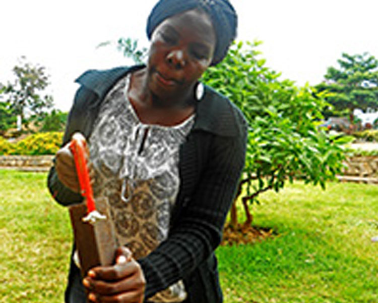 Here, Betty demonstrates a hand powered charcoal press. 