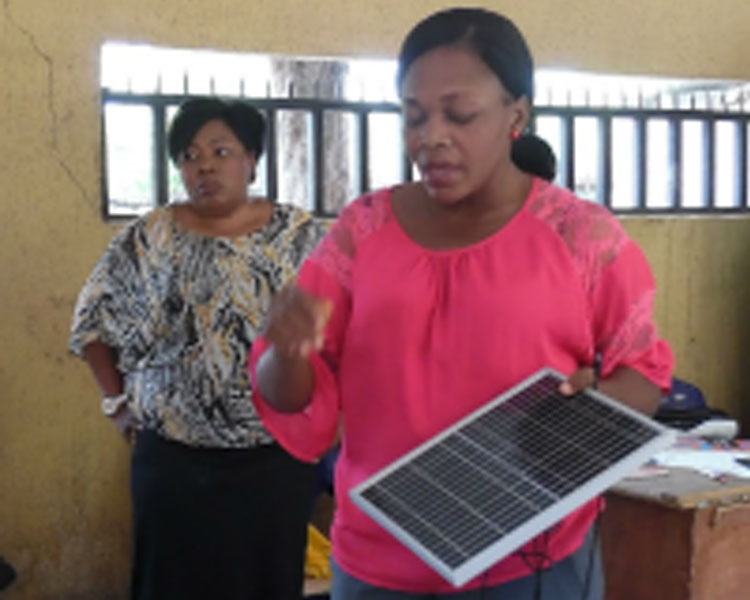 Describing how a solar panel works to local school students (Nigeria).