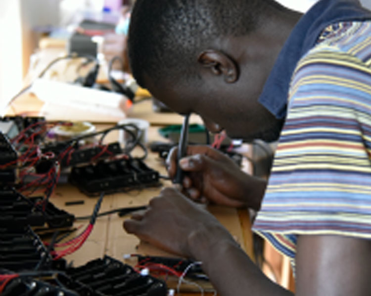 Makerere engineering student Denis Okotel works on sensor electronics.