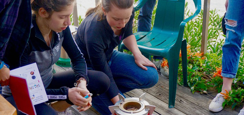 Team members Cayanne and Natalia carrying out tests on the Mimi Moto cookstove with the help of Richard Grinnell - Regional Director of Global Alliance for Clean Cookstoves.