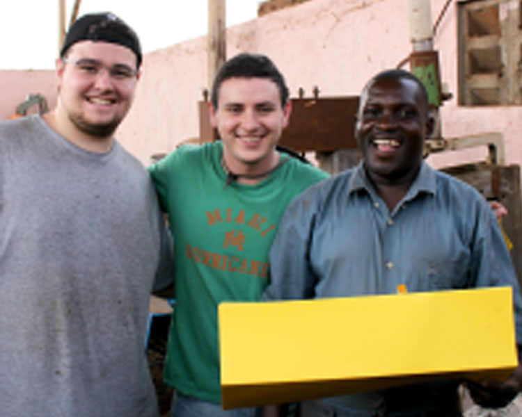 Tim, Drew, and Juma (Central Engineering) show off a sketch model of their idea to modify the charcoal grinder. (Photo: Lauren Bustamante)