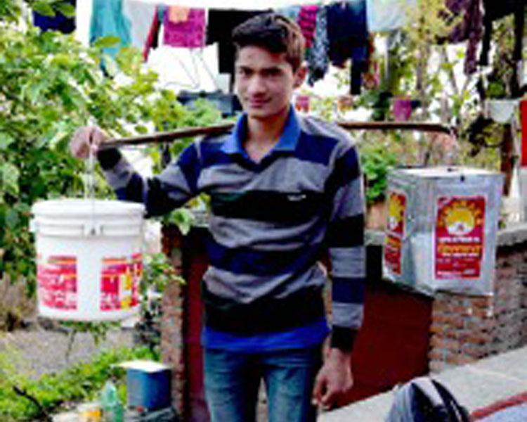 A young man carrying water collected at a natural spring. 