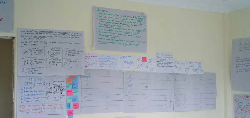 Wall covered with notes written on large pieces of paper.