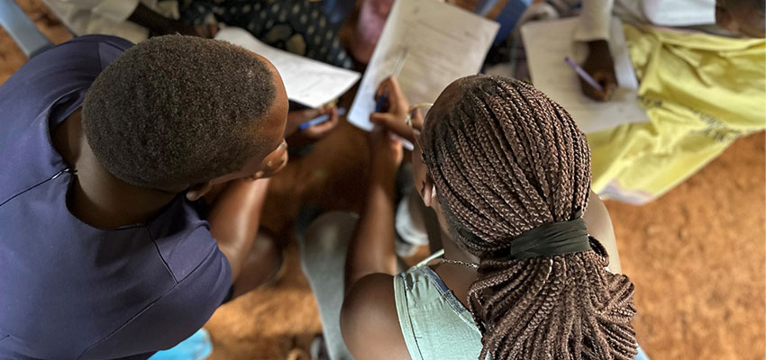 Two people consulting a piece of paper - photo taken from above and behind their heads.