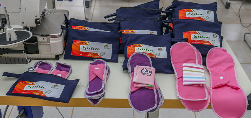 Small piles of washable sanitary pads and branded bags.