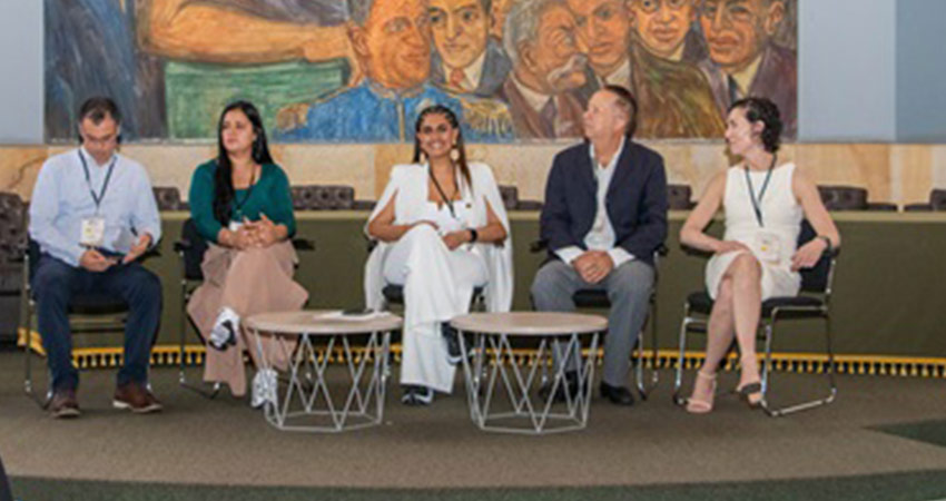Five people sitting on a stage for a panel discussion.