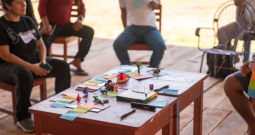 a low table in the foreground with some small objects and parts of seated individuals in the background.