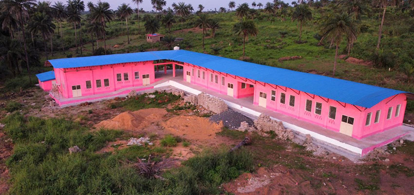 L-shaped one story building under construction - pink insulation lines the building.