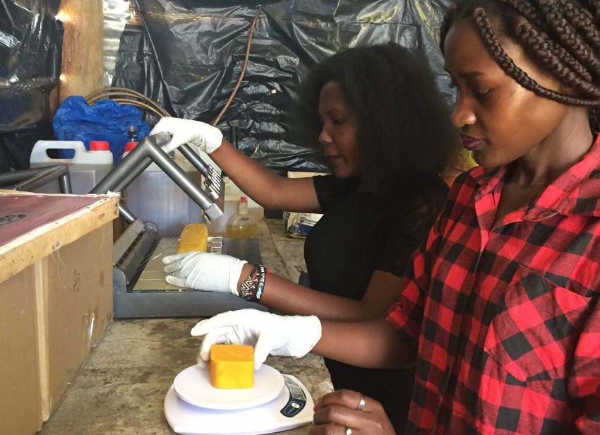 Joan Nalubega (back) and Monica Nantongo are putting the final touches on a batch of their mosquito-repellent soap. Joan’s company, Uganics, has tested their product in Germany. The company sells to individuals as well as businesses, such as hotels. 